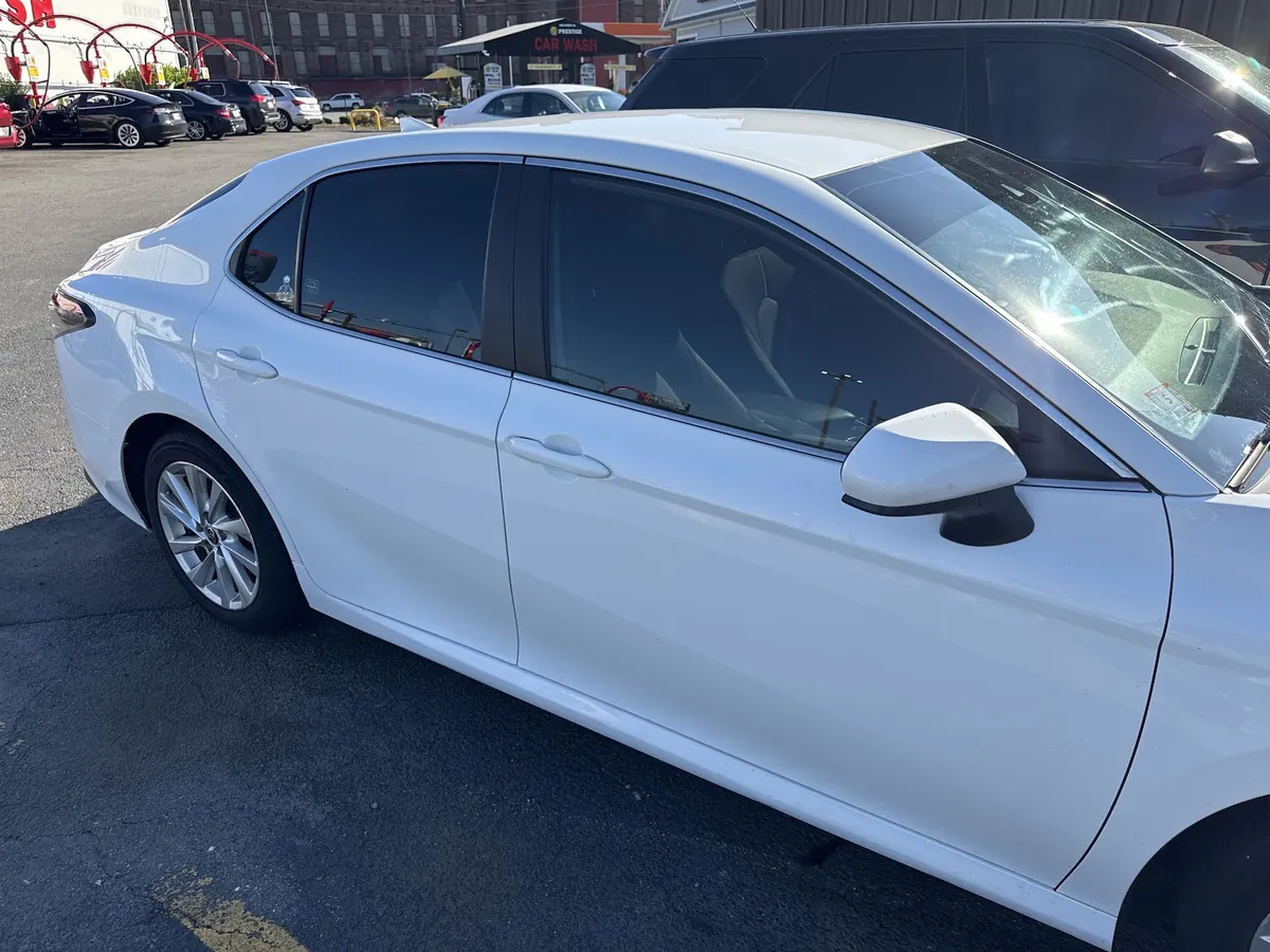 White Toyota Camry with tinted windows parked outside