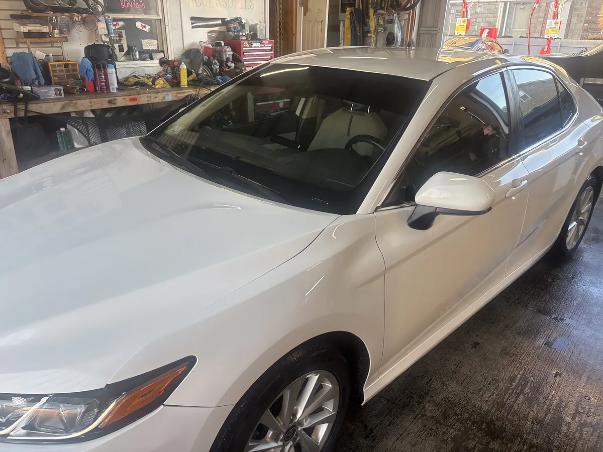 Pearl white Toyota Camry with tinted windows in the bay